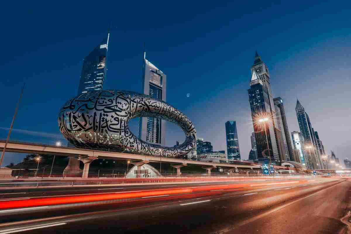 Experts immobiliers francophones conseillant un client à Dubaï, gratte-ciels modernes en arrière-plan.