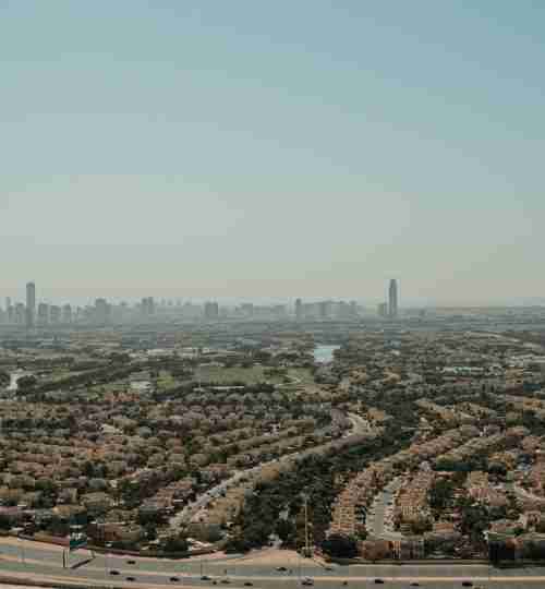 Vue aérienne de Dubai Hills Estate, quartier résidentiel premium avec golfs et gratte-ciels, idéal pour investir à Dubaï